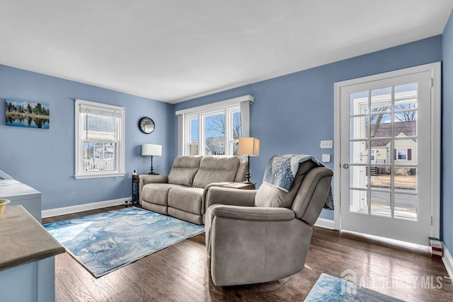 living area with baseboards, plenty of natural light, and wood finished floors