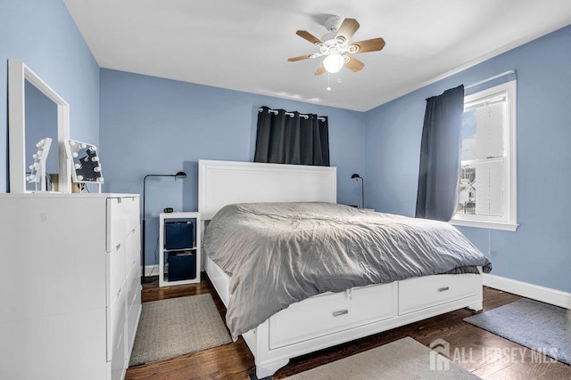 bedroom with a ceiling fan, baseboards, and wood finished floors