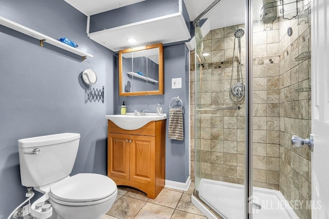 bathroom with vanity, baseboards, a stall shower, tile patterned floors, and toilet