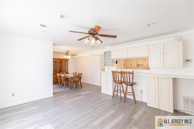 50 Prospect St Unit 09, Metuchen, NJ 08840 - kitchen with a ceiling fan, light wood-type flooring, light countertops, a breakfast bar area, and recessed lighting