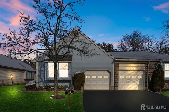 view of front of house with a garage and a yard