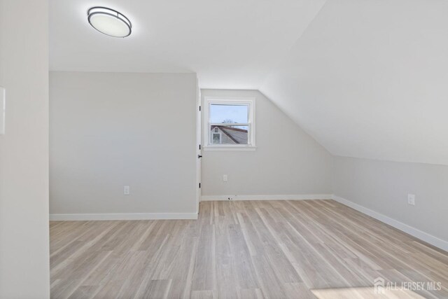 bonus room with light hardwood / wood-style floors and lofted ceiling