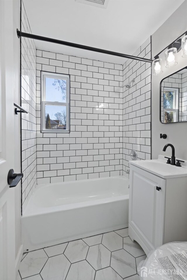 bathroom featuring tile patterned floors, vanity, and tiled shower / bath