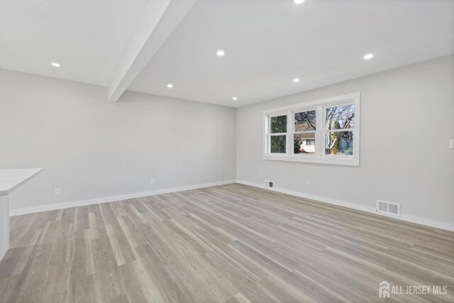 interior space featuring light wood-type flooring and beam ceiling