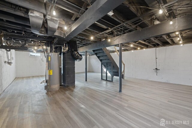 basement with water heater and hardwood / wood-style floors