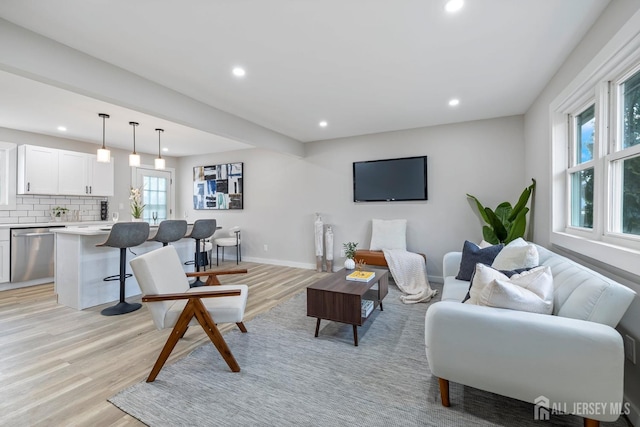 living room featuring baseboards, light wood finished floors, and recessed lighting