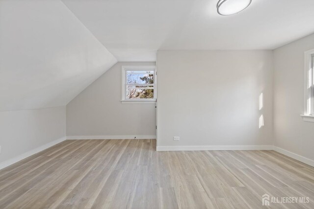 additional living space with lofted ceiling and light hardwood / wood-style floors