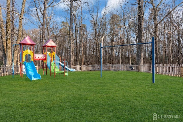 community jungle gym featuring a lawn and fence