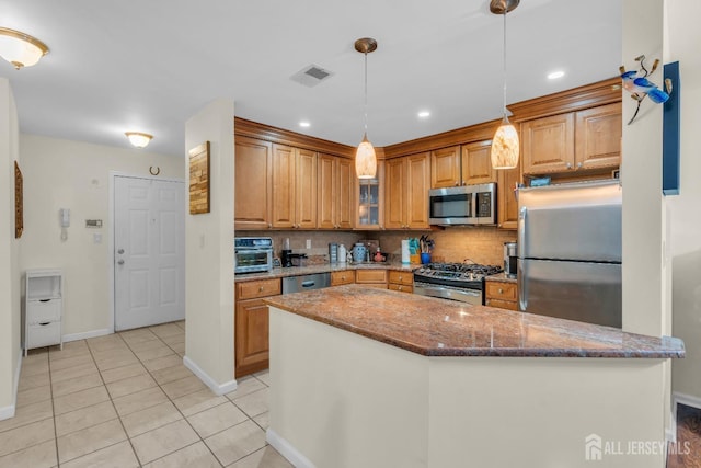 kitchen with dark stone countertops, backsplash, appliances with stainless steel finishes, and light tile patterned floors