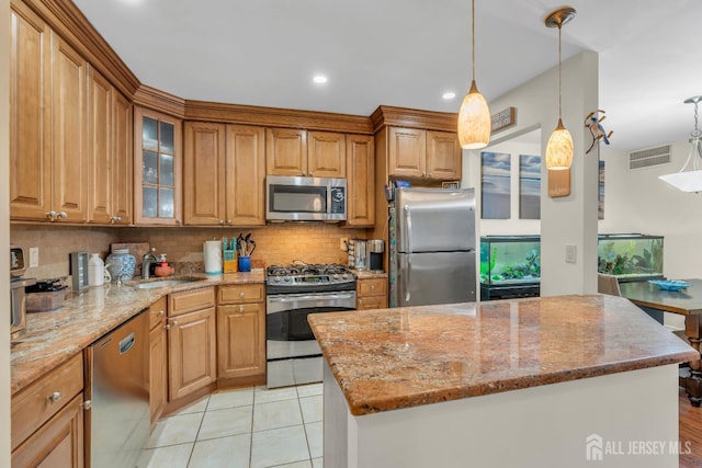 kitchen with light stone counters, visible vents, a sink, stainless steel appliances, and backsplash