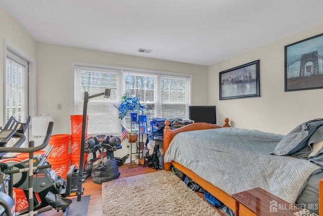 bedroom featuring visible vents and wood finished floors