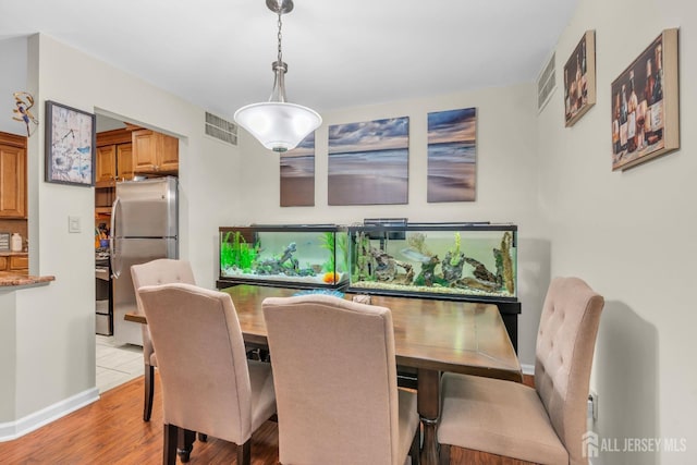 dining space featuring visible vents, baseboards, and light wood-style floors