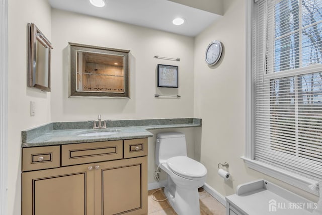 bathroom with baseboards, toilet, recessed lighting, tile patterned floors, and vanity