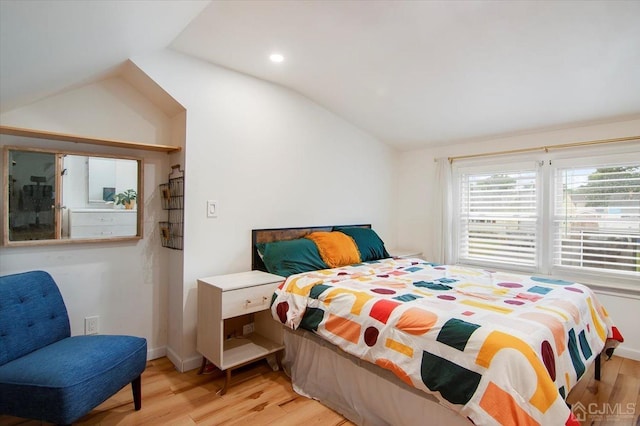 bedroom featuring light hardwood / wood-style flooring and lofted ceiling