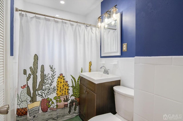 bathroom featuring tile walls, toilet, and vanity