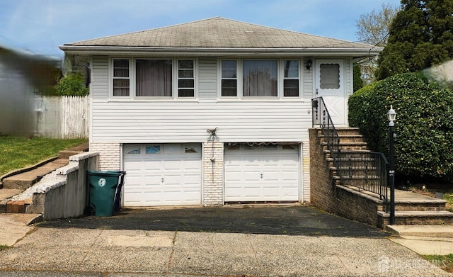 694 Vincent Pl, Perth Amboy, NJ 08861 - view of front of property featuring a garage, asphalt driveway, and roof with shingles