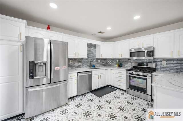 202 Canterbury Way S, Brunswick, NJ 08540 - kitchen with appliances with stainless steel finishes, white cabinets, a sink, tasteful backsplash, and light stone counters