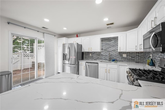 202 Canterbury Way S, Brunswick, NJ 08540 - kitchen featuring stainless steel appliances, a sink, white cabinets, light stone countertops, and tasteful backsplash