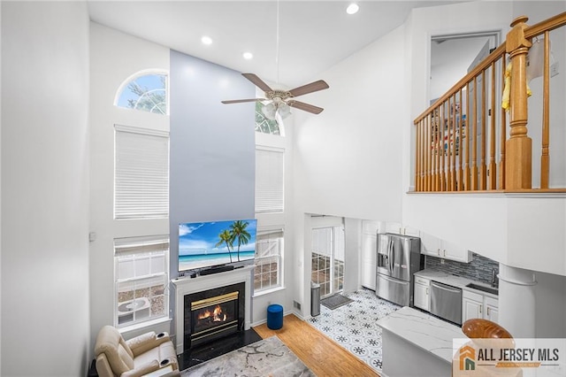 202 Canterbury Way S, Brunswick, NJ 08540 - living area featuring a towering ceiling, a ceiling fan, recessed lighting, a fireplace, and light wood-style floors