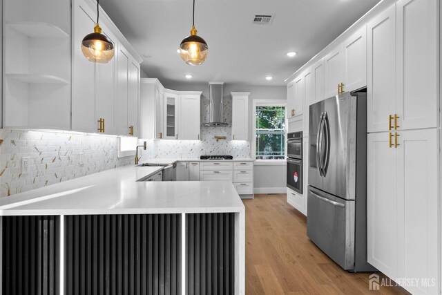 75 Jefferson Blvd, Edison, NJ 08817 - kitchen with appliances with stainless steel finishes, wall chimney exhaust hood, a peninsula, white cabinets, and open shelves