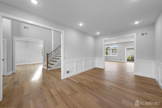 75 Jefferson Blvd, Edison, NJ 08817 - empty room featuring a decorative wall, stairway, light wood-type flooring, wainscoting, and recessed lighting