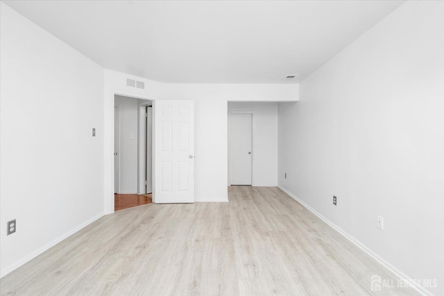 unfurnished bedroom with light wood-type flooring, visible vents, and baseboards