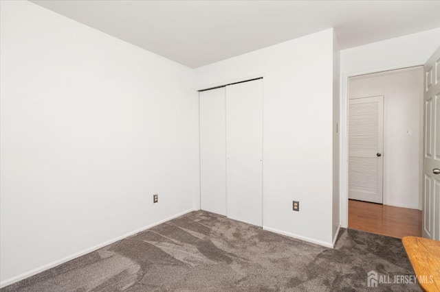 unfurnished bedroom featuring carpet floors, a closet, and baseboards