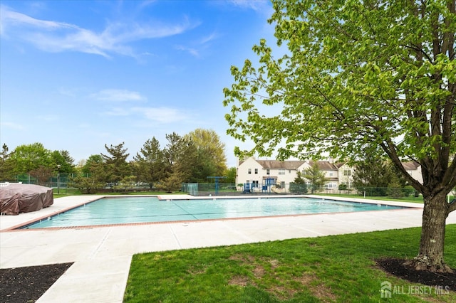 community pool with a yard, a patio area, and fence