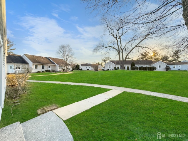 view of grassy yard featuring a residential view