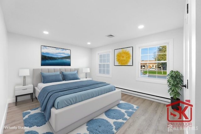 bedroom with baseboard heating, wood finished floors, and recessed lighting