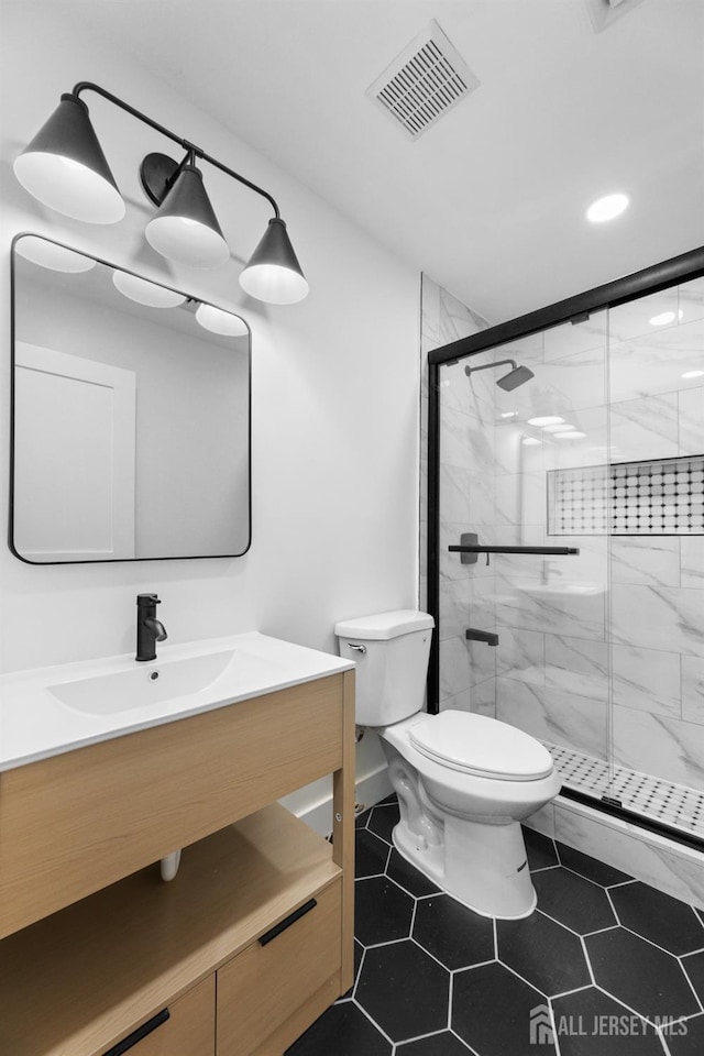 bathroom with toilet, a shower stall, vanity, recessed lighting, and tile patterned floors