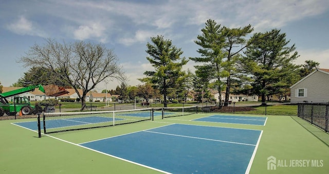 view of tennis court with community basketball court and fence