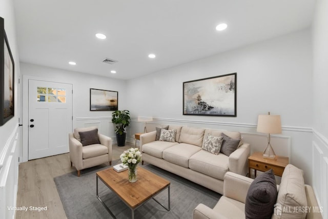 living area with light wood-style flooring and recessed lighting