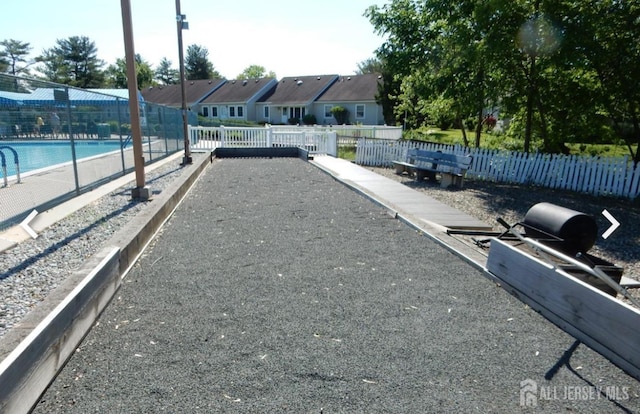 view of property's community featuring a game area, fence, and a residential view