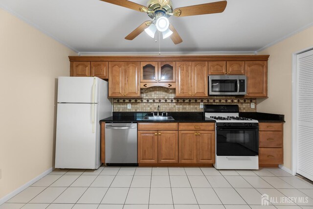 1004 Cricket Ln, Woodbridge Proper, NJ 07095 - kitchen with appliances with stainless steel finishes, ornamental molding, dark countertops, brown cabinets, and tasteful backsplash
