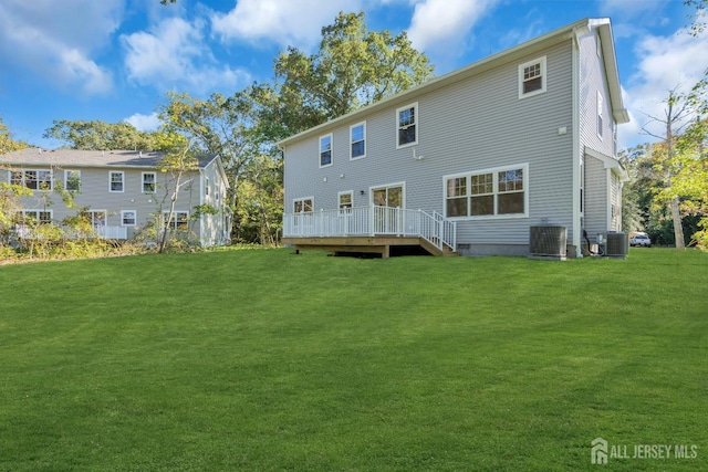 rear view of house featuring a wooden deck, central AC unit, and a lawn