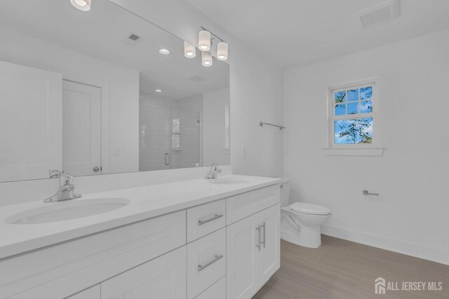 bathroom featuring a shower with door, toilet, wood-type flooring, and vanity