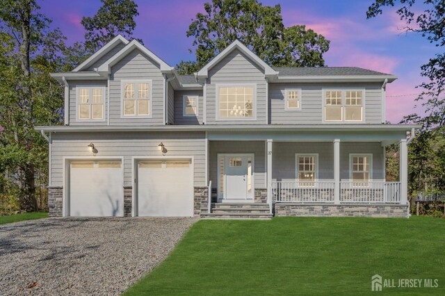 view of front of home featuring a garage, a lawn, and a porch