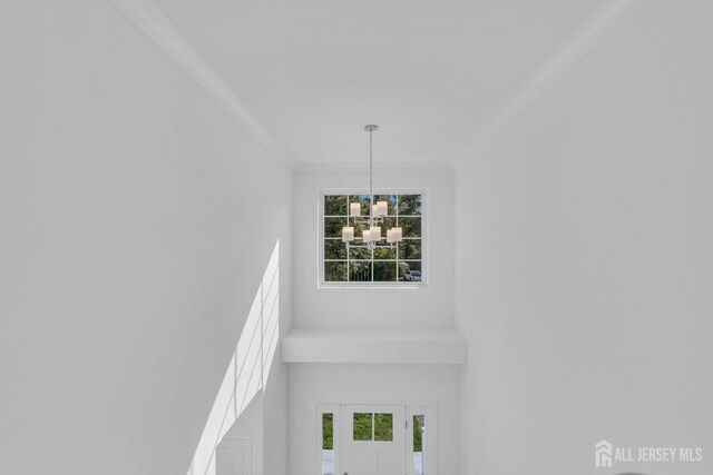 interior details featuring crown molding and an inviting chandelier