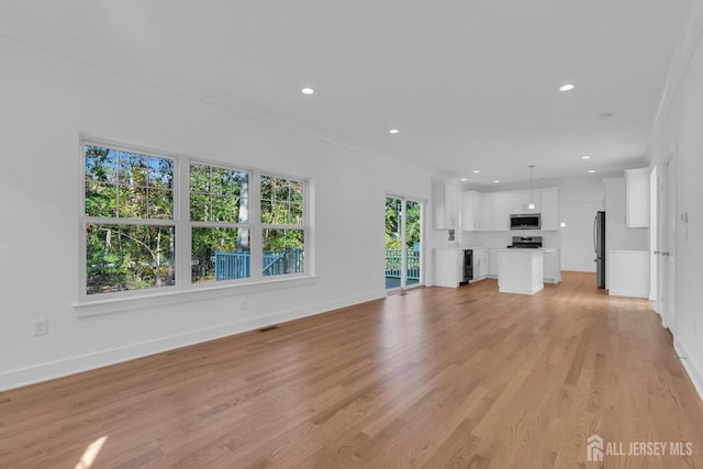 unfurnished living room with ornamental molding and light hardwood / wood-style flooring