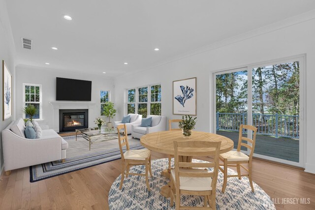 dining room with crown molding and light hardwood / wood-style flooring