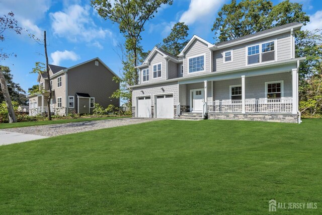 view of front facade with covered porch, a front yard, and a garage