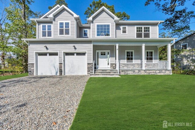 view of front of house featuring a front yard, a garage, and a porch