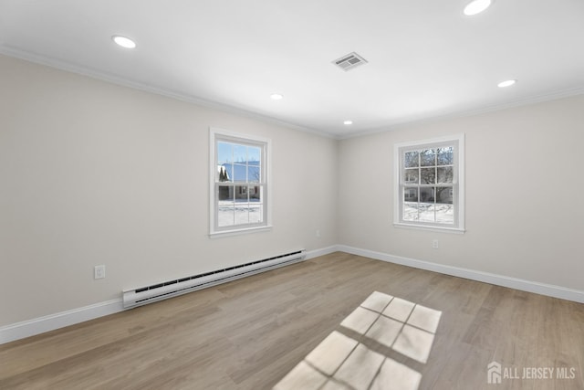 unfurnished room with visible vents, a baseboard heating unit, ornamental molding, wood finished floors, and baseboards