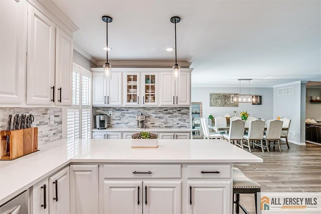 22 Kentnor St, Metuchen, NJ 08840 - kitchen featuring white cabinets, tasteful backsplash, pendant lighting, light countertops, and ornamental molding