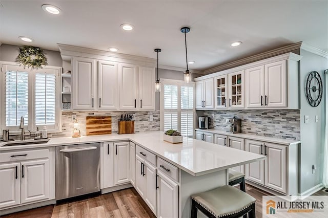 22 Kentnor St, Metuchen, NJ 08840 - kitchen featuring dishwasher, a sink, a peninsula, crown molding, and white cabinetry