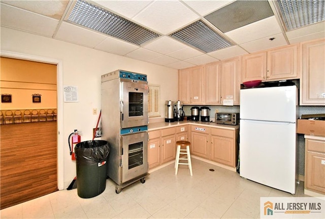525 Harrier Dr Unit 525, Monroe, NJ 08831 - kitchen with freestanding refrigerator, light brown cabinets, a drop ceiling, decorative backsplash, and light floors