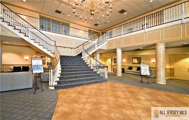 525 Harrier Dr Unit 525, Monroe, NJ 08831 - stairway with ornate columns, a towering ceiling, tile patterned flooring, a chandelier, and carpet flooring