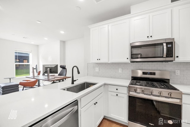 kitchen featuring stainless steel appliances, decorative backsplash, white cabinets, and sink