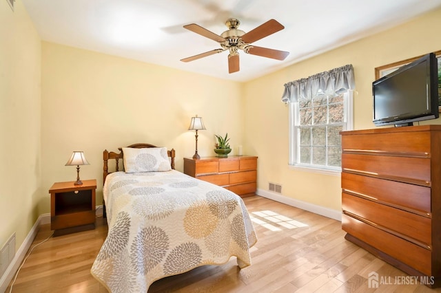 bedroom with light wood finished floors, baseboards, and a ceiling fan